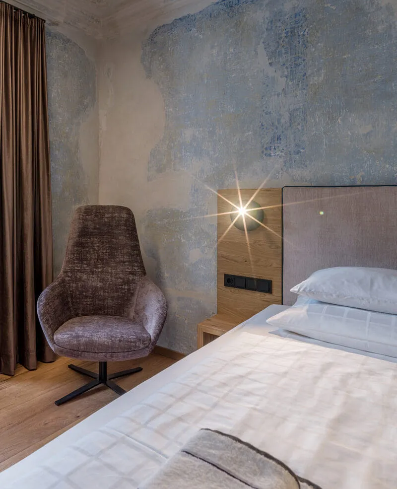 Hotelzimmer mit Sessel und Polsterbett